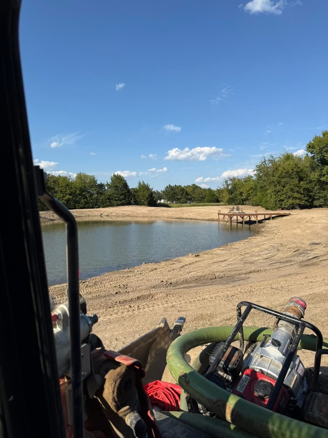 View from the operator's seat over a finished pond and graded bank